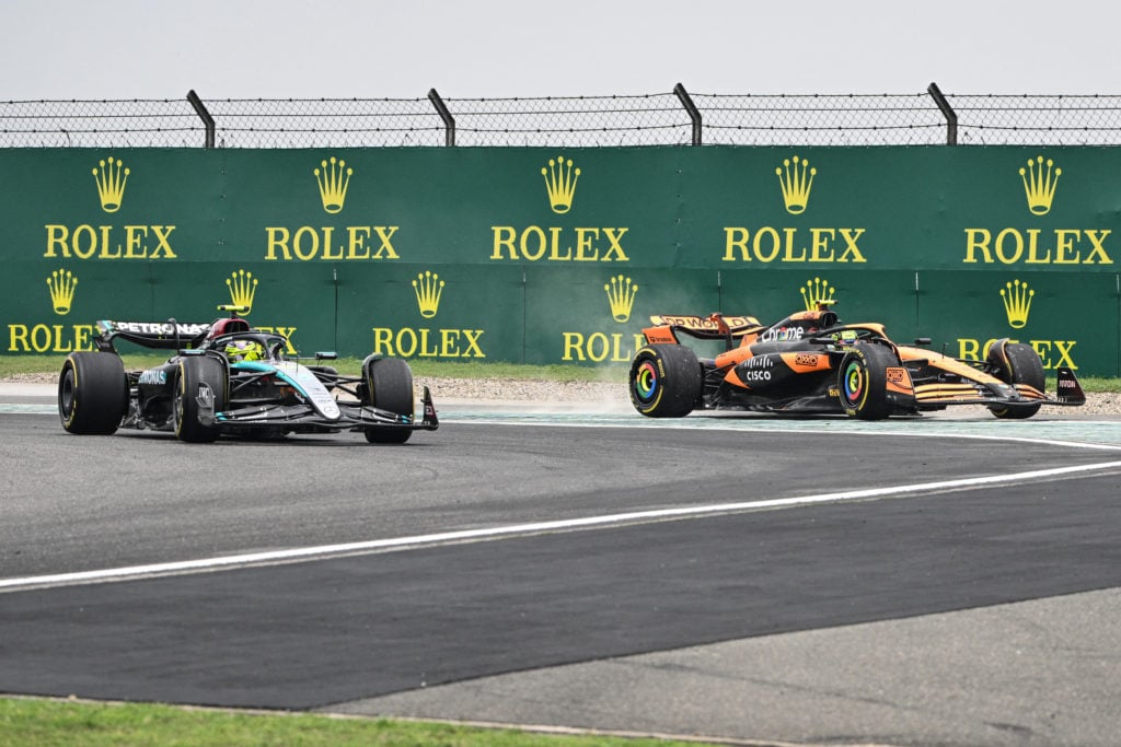 Mercedes' British driver Lewis Hamilton (L) and McLaren's British driver Lando Norris (R)  fight for the lead at the second corner of the first lap...