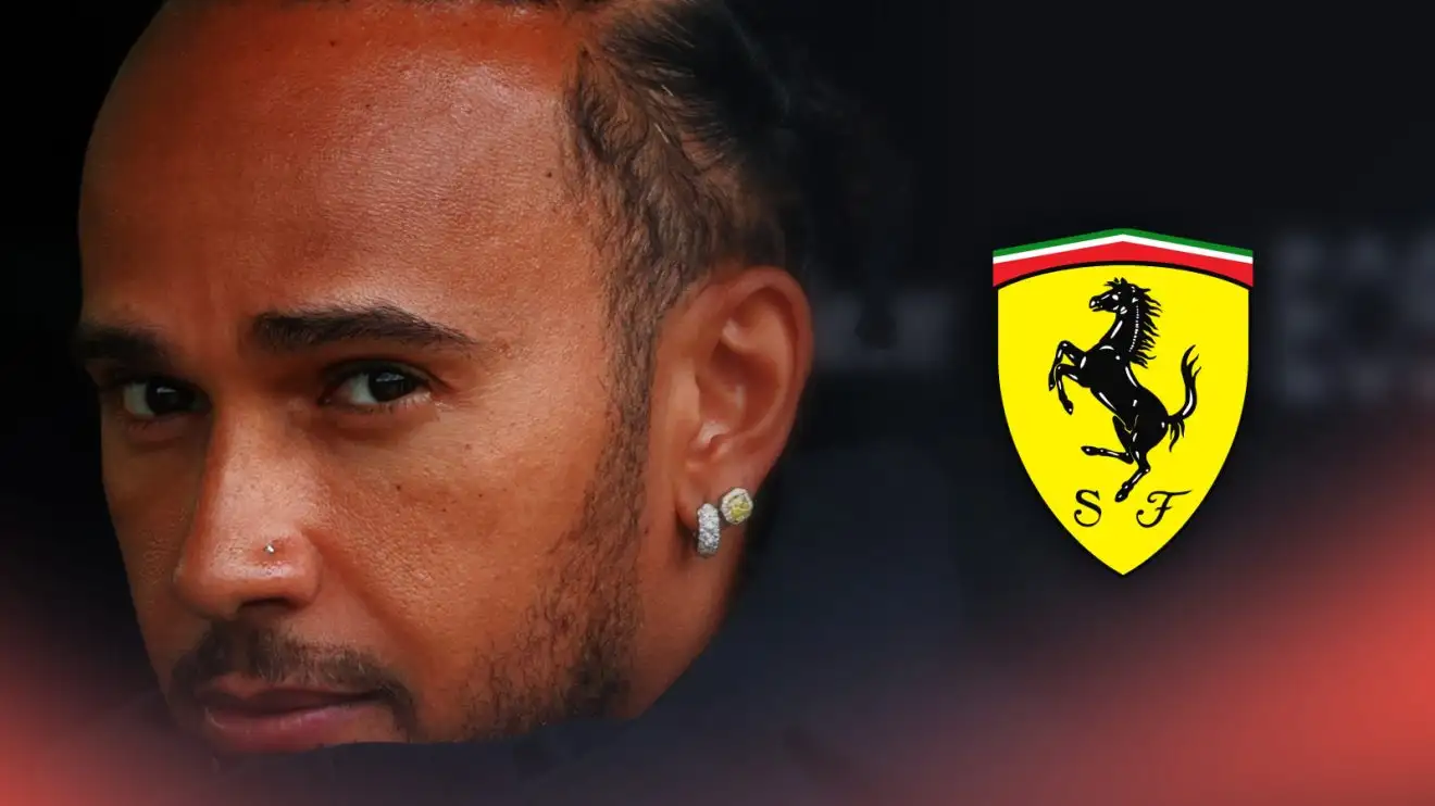 c-364 Lewis Hamilton tucks his chin into his coat at a cold Imola with a prominent Ferrari logo alongside him