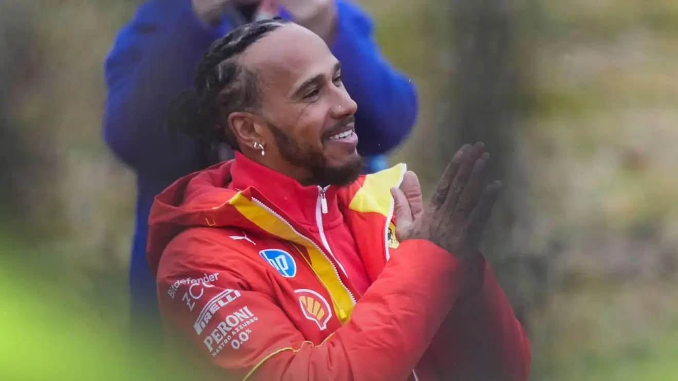 c-435 Lewis Hamilton smiles and holds his hands up in thanks to fans at Fiorano