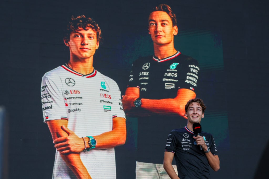 gettyimages-2178599888-1024x683-1 Mercedes AMG Petronas F1 Team driver George Russell (63) of the United Kingdom speaks at the Fan Forum with a photo of himself and future teammate ...
