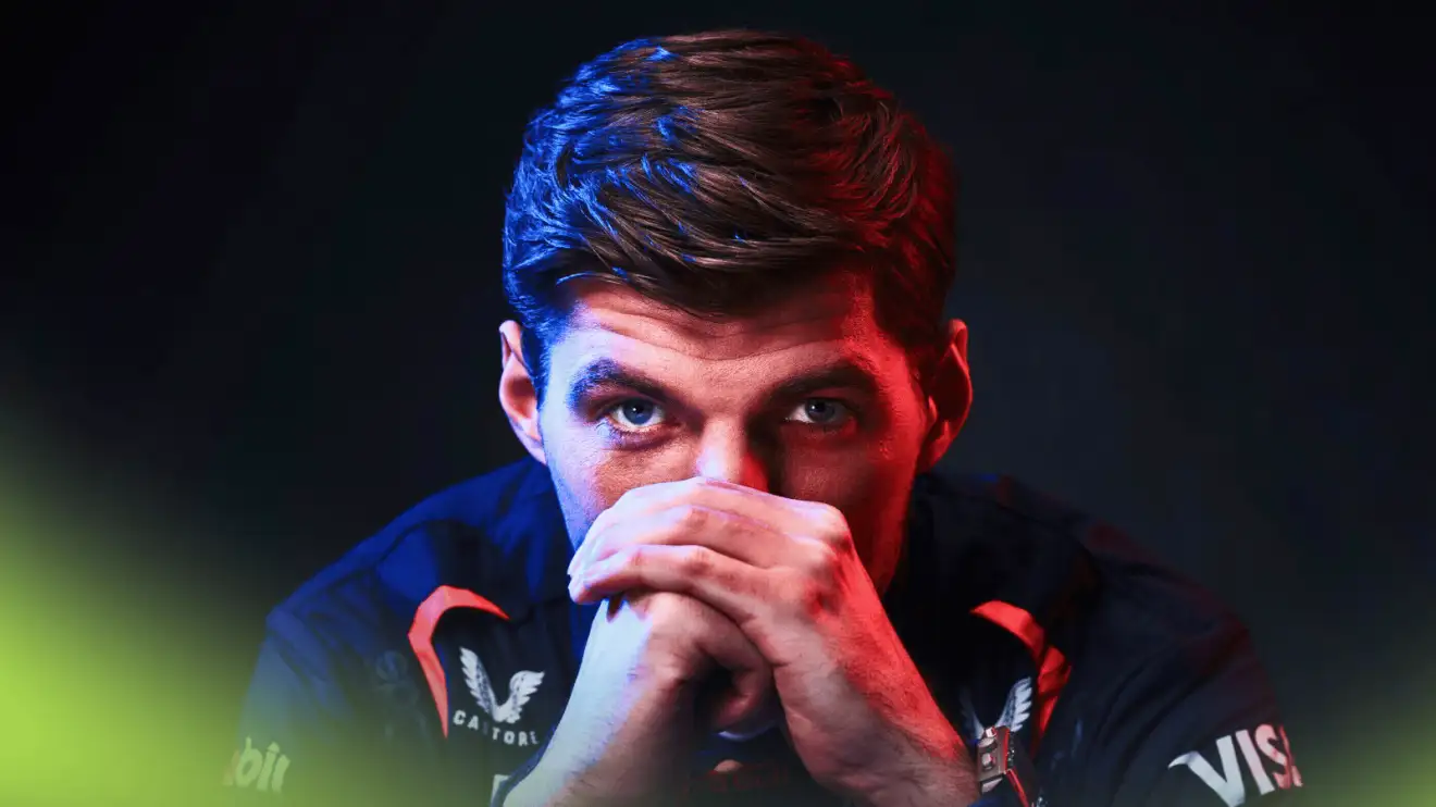 A menacing shot of Max Verstappen eyeing the camera with his hands covering his mouth