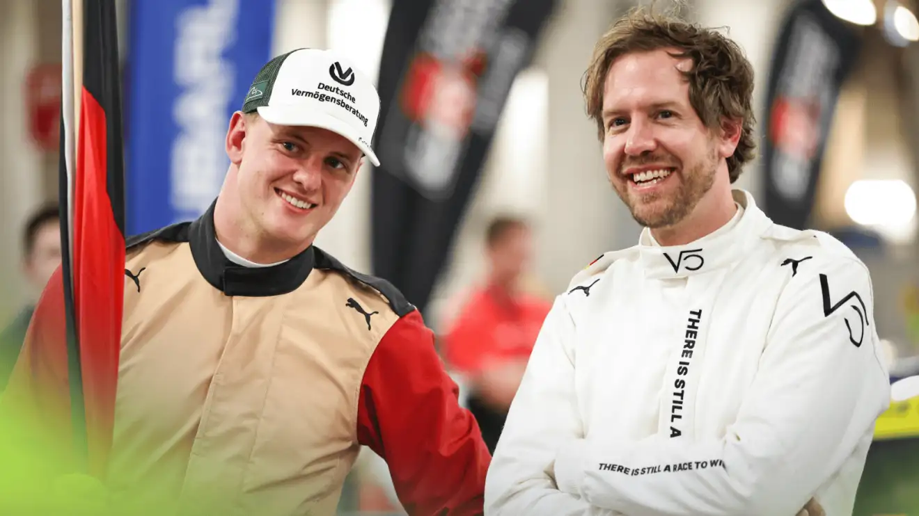 Mick Schumacher and Sebastian Vettel smile as they stand together at the Race of Champions