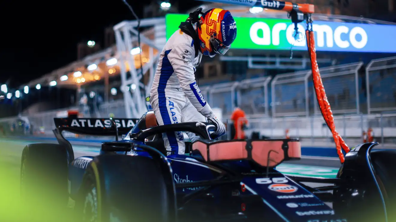 A dramatic shot of Carlos Sainz stepping out of his Williams FW47 in the Bahrain pit lane