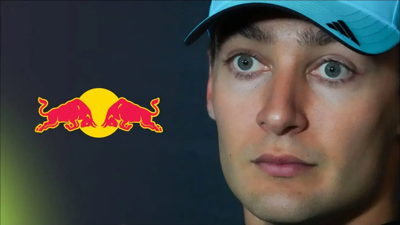 c-1386 A close-up shot of George Russell wearing a blue Mercedes cap with a prominent Red Bull logo alongside him