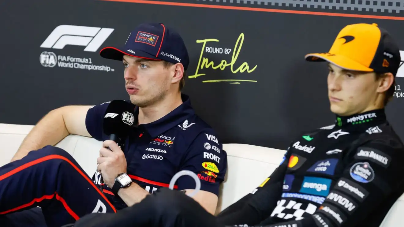 c-1062 Max Verstappen holding the mic during a press conference, Oscar Piastri sitting next to him