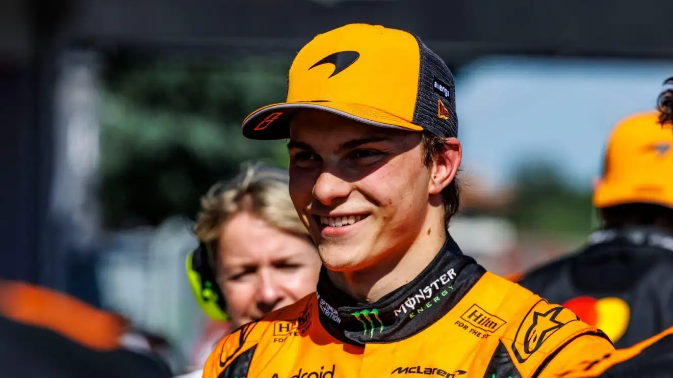 c-1200 Oscar Piastri smiles while wearing a McLaren team cap in parc ferme.