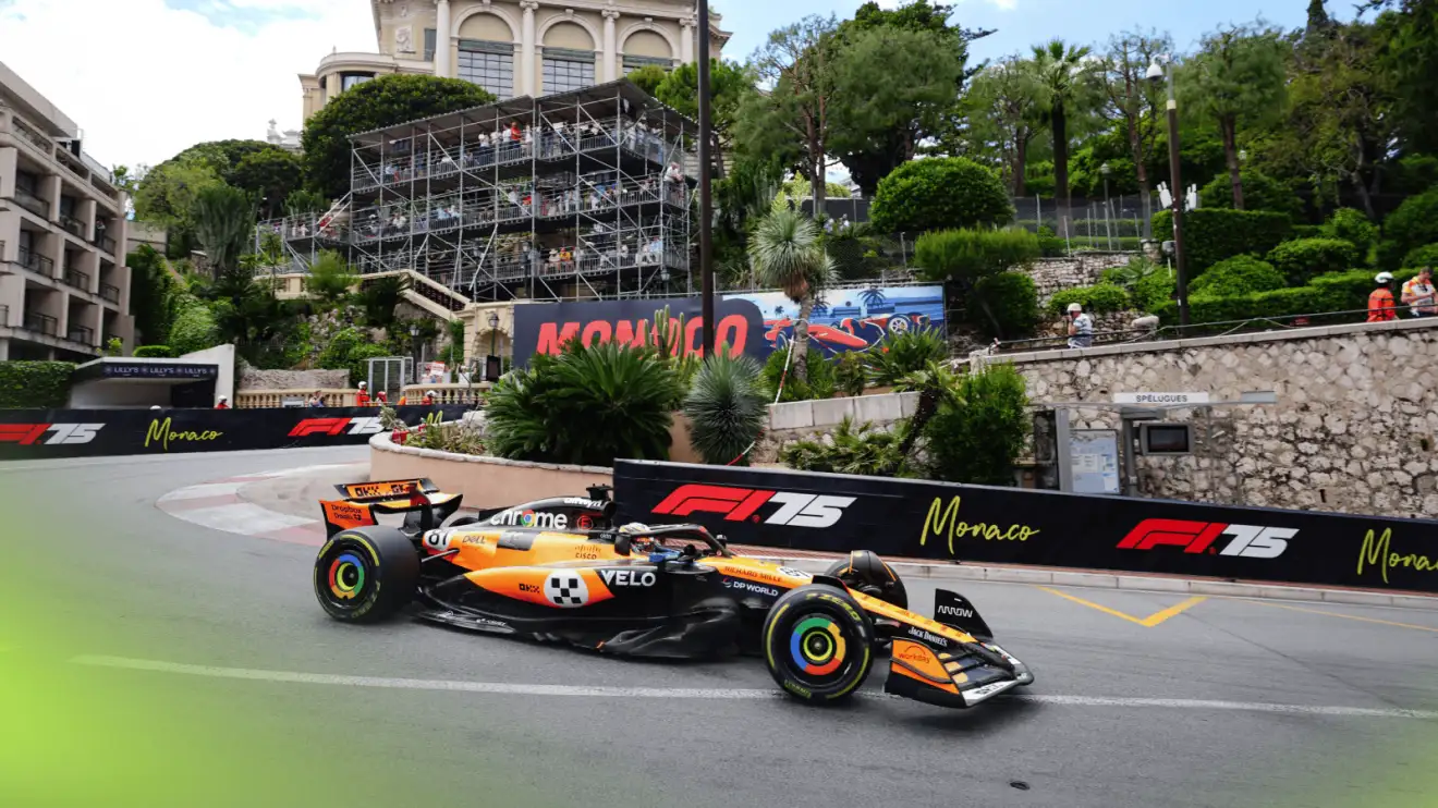 c-1299 Oscar Piastri's McLaren on track in Monaco with the local scenery in the backdrop