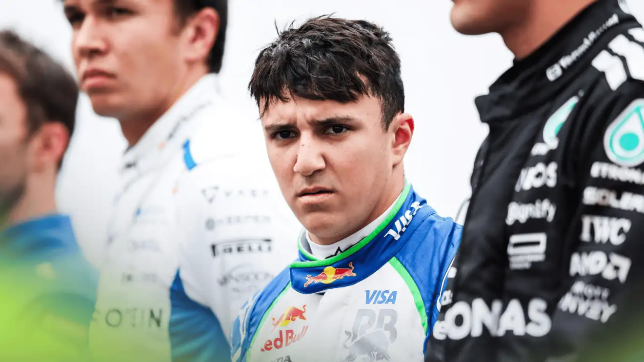 c-1556 Isack Hadjar scowls at the camera as he lines up alongside Alex Albon and George Russell for the national anthem at Suzuka