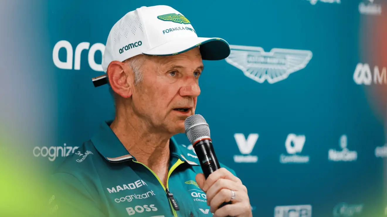 Adrian Newey holds a microphone as he faces the media in Monaco