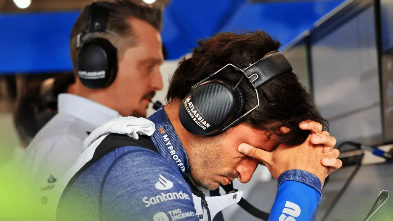 c-282 Carlos Sainz holds his hands to his face as he studies screens in the Williams garage