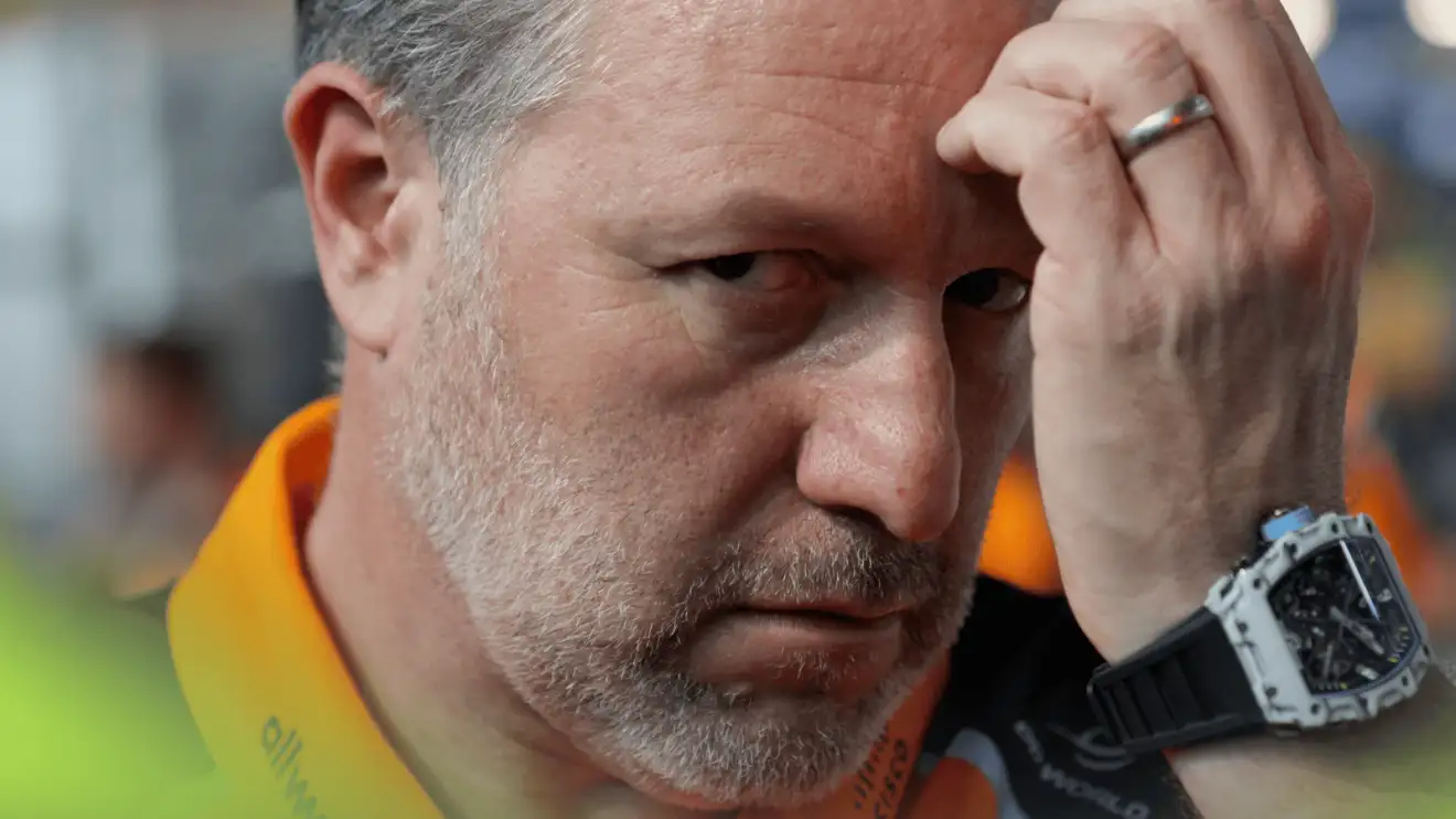 c-563 A close-up shot of Zak Brown eyeing the camera as he rubs his forehead on the grid in Jeddah