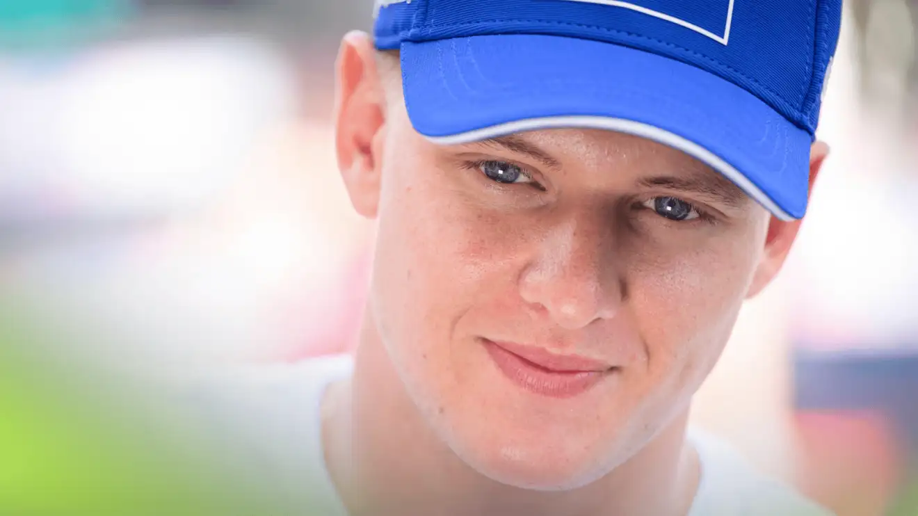 c-572 A close-up shot of Mick Schumacher smiling thinly at the 2022 Monaco Grand Prix
