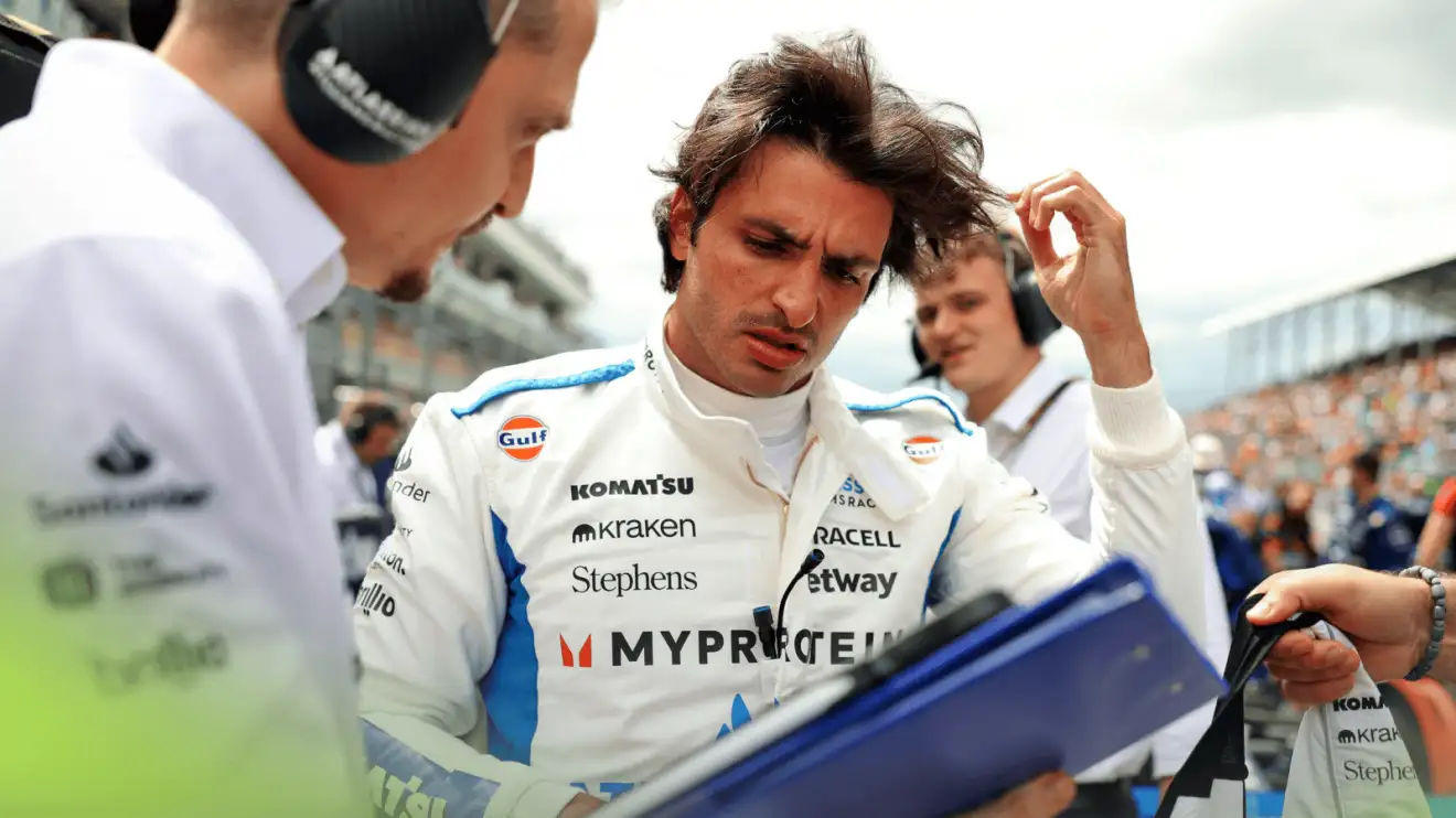 c-614 Carlos Sainz looks at a folder held by his Williams engineer on the grid in Miami