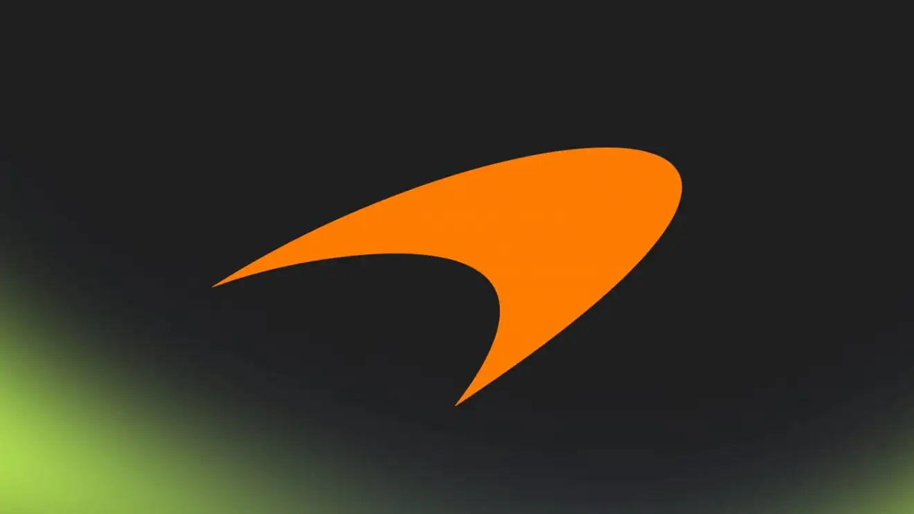 c-866 An orange McLaren logo against a black background with PlanetF1.com's lime-green mist along the bottom