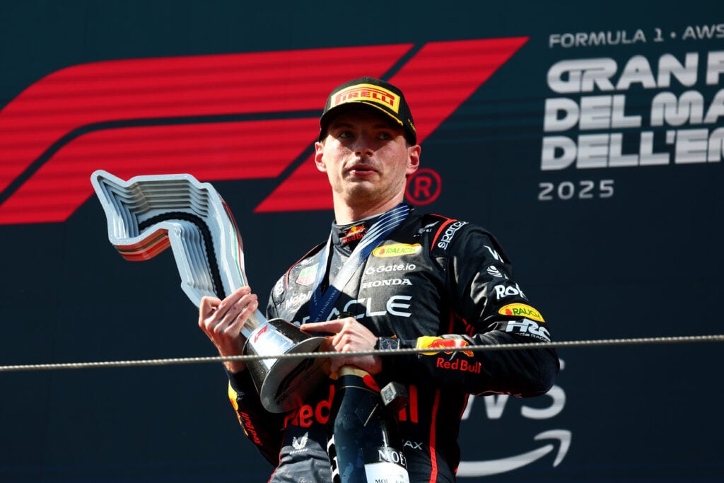 gettyimages-2215727910-1024x683-1 Red Bull Racing driver Max Verstappen standing on the podium with his trophy at the 2025 Emilia Romagna Grand Prix