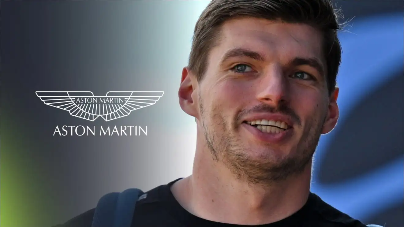 c-483 Max Verstappen smiling in the F1 paddock, with the Aston Martin badge on his left