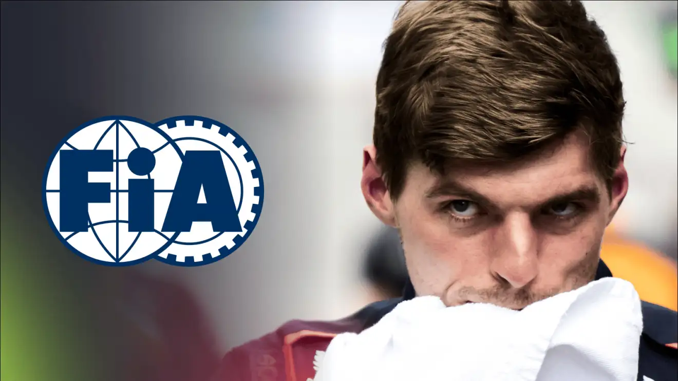c-525 Max Verstappen wipes his face with a towel as a prominent FIA logo sits alongside him