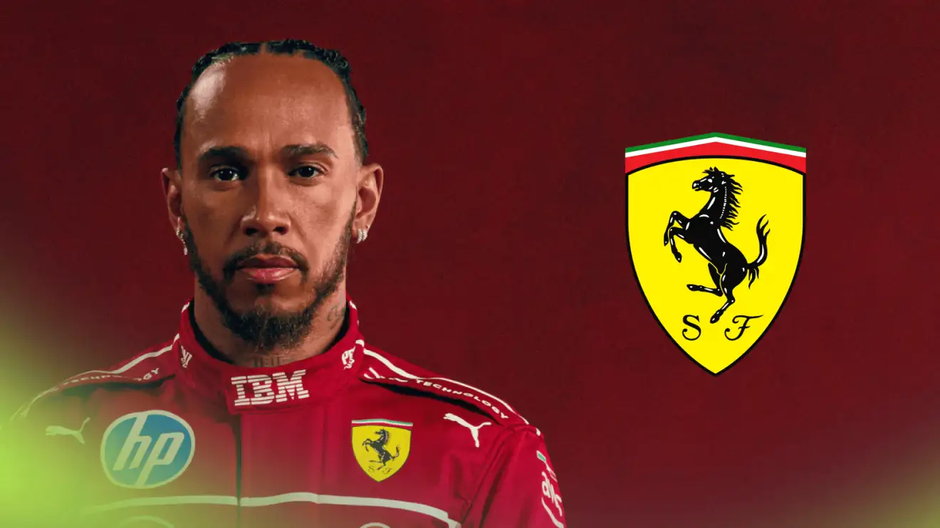 c-531 Lewis Hamilton poses in Ferrari overalls with a prominent Ferrari logo alongside him against a red background