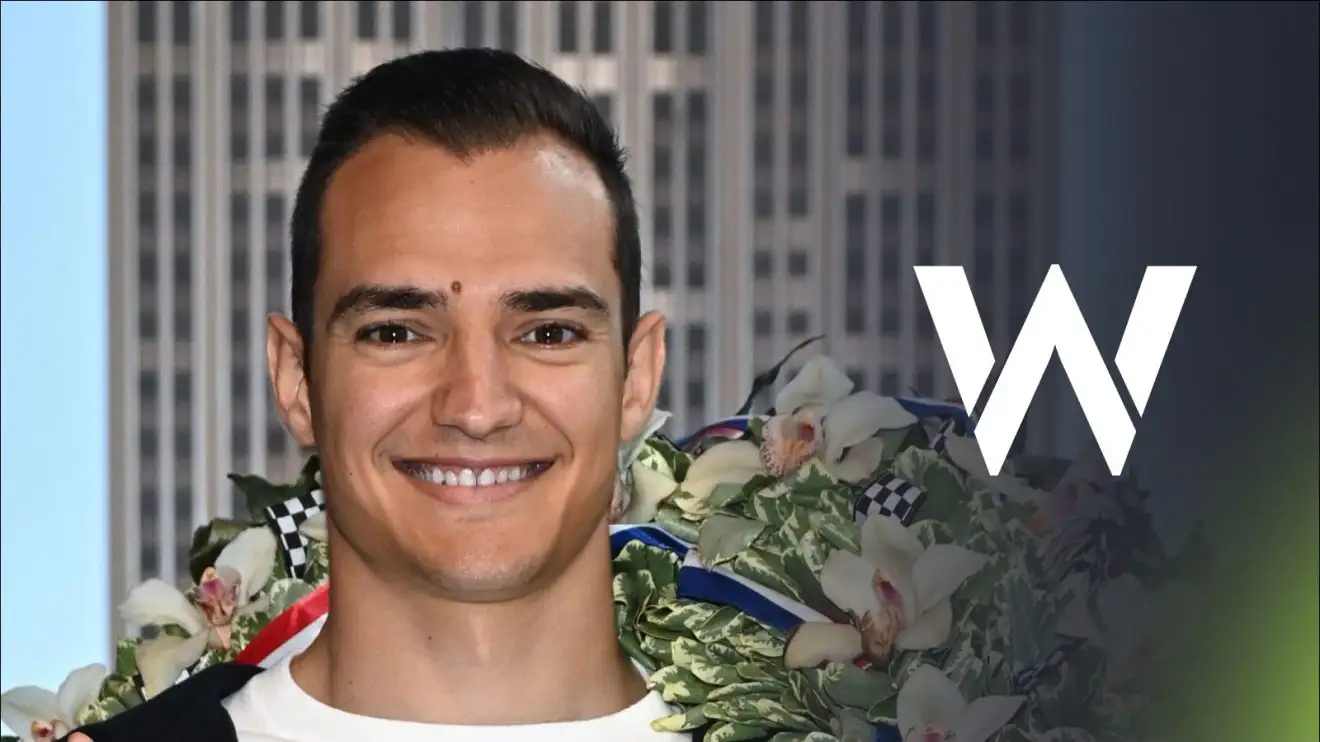 c-572 Alex Palou poses after winning the 2025 Indy 500, with a Williams badge on his right
