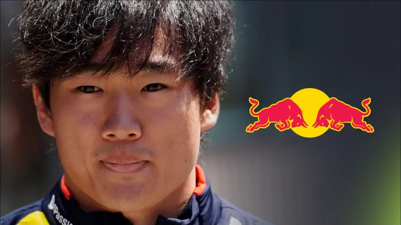 c-587 Yuki Tsunoda pictured at the 2025 Emilia Romagna Grand Prix, with a Red Bull logo to his right