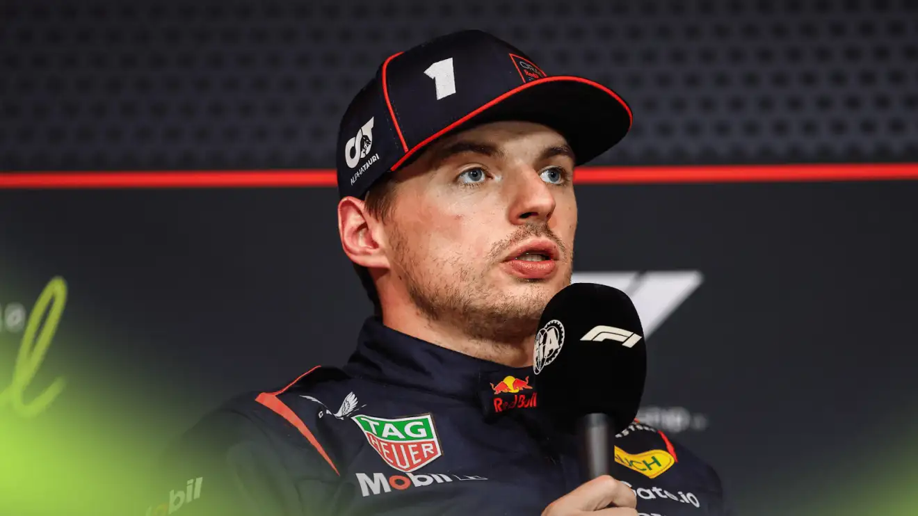 c-886 Max Verstappen speaks into a microphone during a press conference