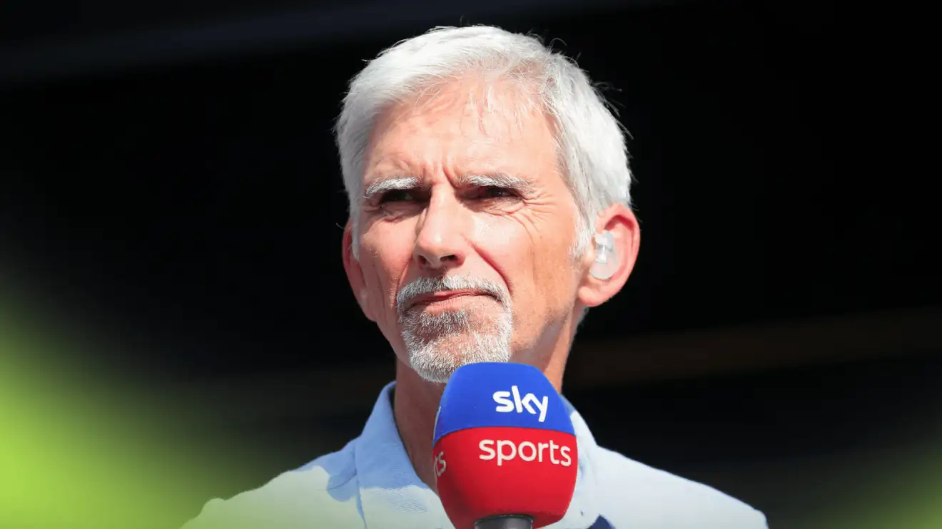 c-985 Damon Hill holds a Sky F1 microphone against a dark background